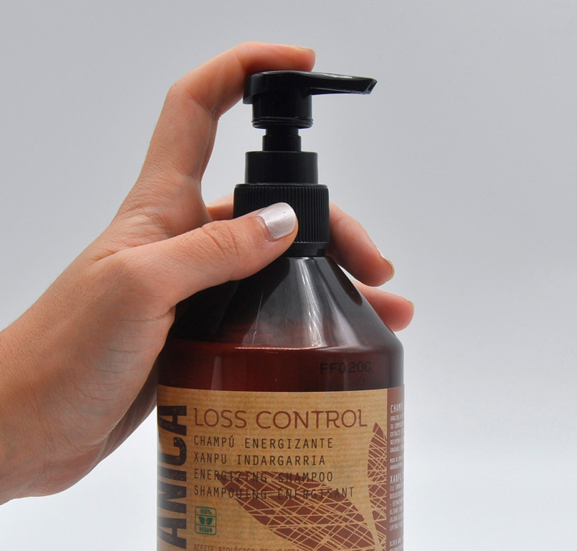 manos sujetando envase champú