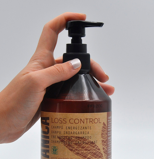 manos sujetando envase champú